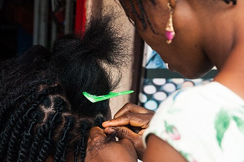 Fatim braiding salon — stylist working on a client