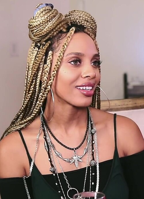 Blonde box braids in a styled half-up bun
